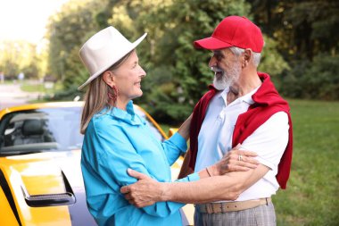 Modern Cabriolet yakınlarında şık bir yaşlı çift.