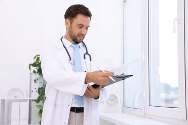 Hastanedeki steteskopu ve panosu olan bir çocuk doktoru.