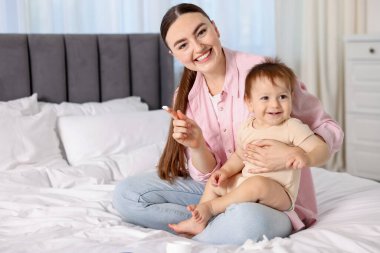 Anne evde bebeğinin vücuduna krem sürüyor.