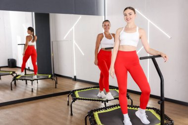 Spor salonundaki trambolinde gülümseyen kadınlar. Metin için boşluk