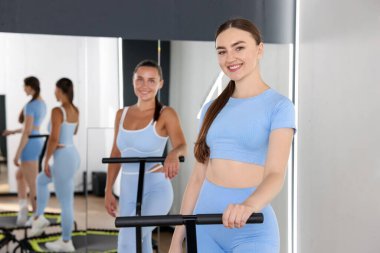 Spor salonundaki trambolinde gülümseyen kadınlar.