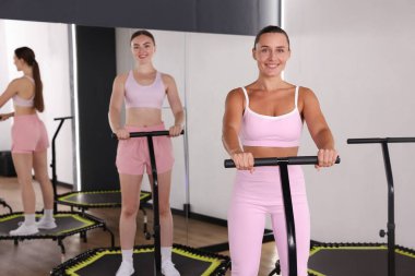 Spor salonundaki trambolinde gülümseyen kadınlar.