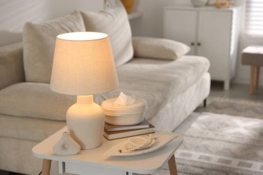 Süslü lamba, dekor ve beyaz masa üzerine kitap.