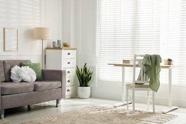 Yumuşak kanepe, masa, şifonyer ve ev bitkisi oturma odasında. İç tasarım