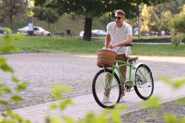 Şehir caddesinde bisikletini gezdiren mutlu bir adam. Metin için boşluk