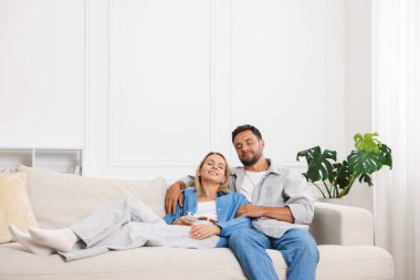 Mutlu çift evdeki kanepede birlikte vakit geçiriyor. Metin için boşluk