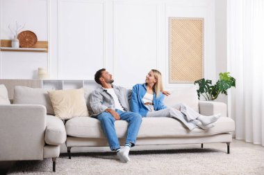 Mutlu çift evdeki kanepede birlikte vakit geçiriyor.