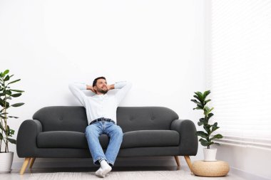 Evdeki kanepede dinlenen mutlu adam. Metin için boşluk