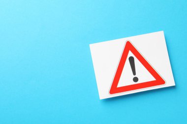 Risk. Açık mavi arkaplanda uyarı işareti, üst görünüm ve metin için boşluk içeren kağıt sayfası