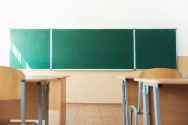 Sınıfta sandalyeli ve yeşil karatahtalı masalar