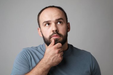 Kellik sorunu. Gri arka planda ince çizgileri olan düşünceli bir adam.