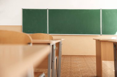 Sınıfta sandalyeli ve yeşil karatahtalı masalar