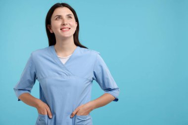 Açık mavi arka planda üniformalı hemşire, metin için boşluk