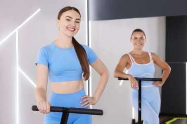 Spor salonundaki trambolinde gülümseyen kadınlar.