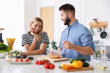 Mutfakta birlikte yemek pişiren mutlu çift.