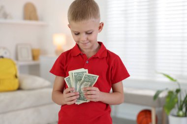 Evde cep harçlığı tutan küçük çocuk.