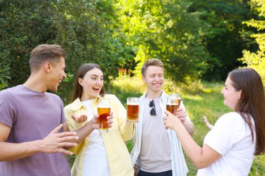 Bir grup mutlu arkadaş dışarıda bira içip eğleniyorlar.