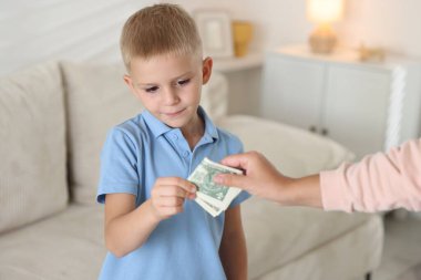 Anne evdeki oğluna harçlık veriyor, yakın plan.