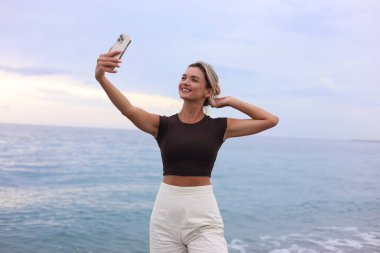 Kumsalda selfie alarak güzel genç kadın