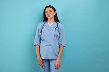 Açık mavi arka planda steteskobu olan hemşire.