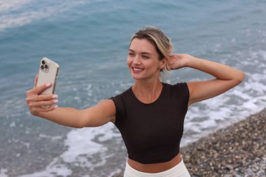 Kumsalda selfie alarak güzel genç kadın