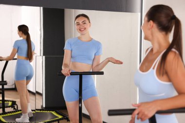 Spor salonundaki trambolinlerde konuşan genç kadınlar.