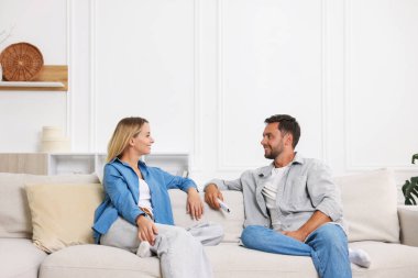 Evdeki koltukta klimalı uzaktan kumandalı bir çift.