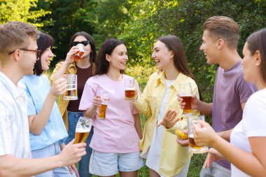 Bir grup mutlu arkadaş dışarıda bira içip eğleniyorlar.