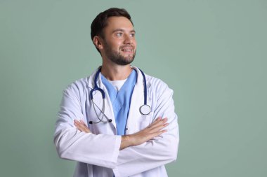 Yeşil arka planda steteskobu olan çocuk doktorunun portresi.