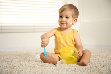 Evinde krem sürmüş şirin bir bebek oynuyor. Metin için boşluk