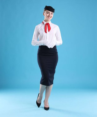 Açık mavi arka planda üniformalı hoş hostes.