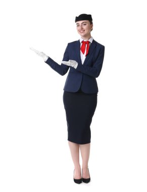 Güzel hostes beyaz arka planda bir şey gösteriyor.