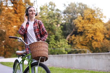 Parkta bisiklet sürerken müzik dinleyen güzel bir kadın. Metin için boşluk