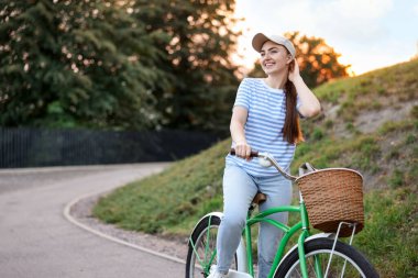 Şehir caddesinde bisiklet süren mutlu bir kadın. Metin için boşluk