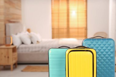 Hotel room with comfortable furniture and guest suitcases, selective focus