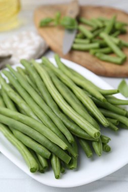 Cut green bean pods on white table, closeup