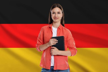 Almanya bayrağına karşı not defteri olan öğrenci. Dil okulu