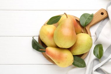 Taze armutlar ve beyaz ahşap masa üzerinde yeşil yapraklar. Metin için boşluk