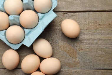 Ahşap masada çiğ tavuk yumurtası, üst manzara. Metin için boşluk