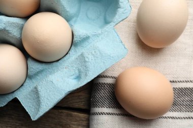 Fresh raw chicken eggs on wooden table, above view