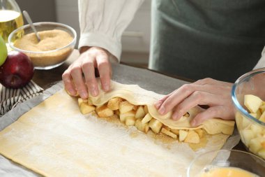 Mutfaktaki masada lezzetli elmalı turta yapan kadın, yakın plan.