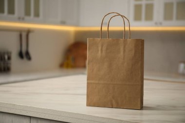 Mutfaktaki beyaz mermer masada kağıt torba. Metin için boşluk