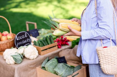 Çiftçi pazarından taze sebze seçen kadın, yakın plan.
