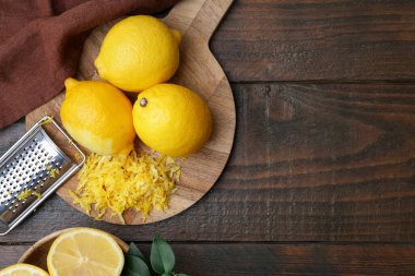 Lemon zest, fresh fruits and grater on wooden table. Space for text