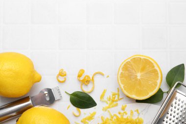 Limon aroması, taze meyve, aletler ve yeşil yapraklar beyaz fayanslı masa, düz yatak. Metin için boşluk