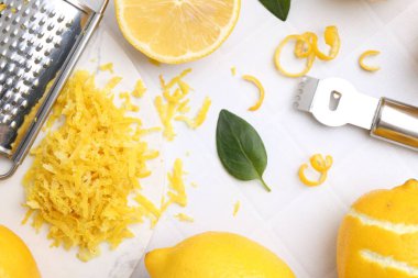 Limon aroması, taze meyve, aletler ve yeşil yapraklar beyaz fayanslı masada, düz yatıyordu.