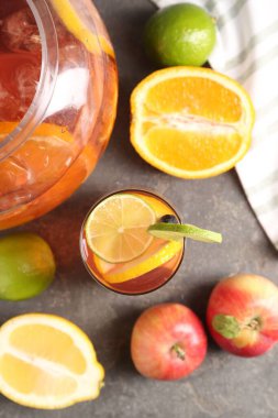 Punch and fresh fruits on grey table, flat lay. Refreshing drink
