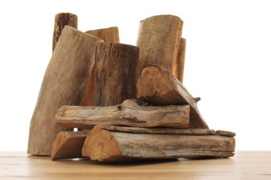 Ahşap masa üzerine kesilmiş odun yığını beyaz arka plana karşı