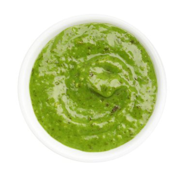 Fresh pesto sauce in bowl isolated on white, top view