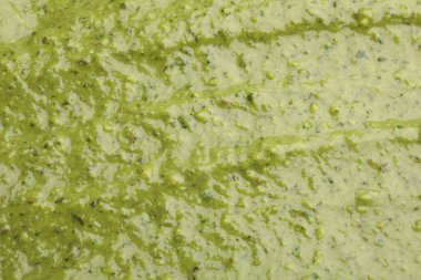 Arka plan olarak lezzetli yeşil pesto sosu, üst görünüm